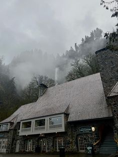 the front of a stone building with fog coming in