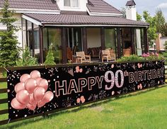 a happy 90th birthday banner with balloons in front of a house on the lawn