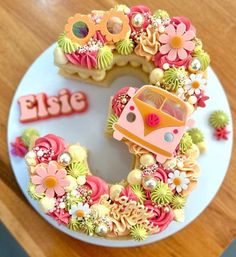 a decorated cake with the letter e on it's side and flowers in the middle