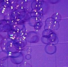 soap bubbles floating in the air on a tiled wall