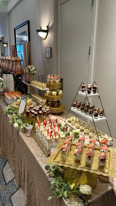 an assortment of desserts are displayed on a long table in a banquet or function hall