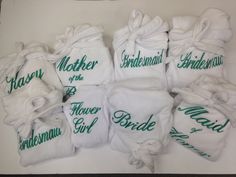 seven bridesmaids are wrapped in white towels and tied with green lettering on them