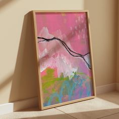 an abstract painting is displayed in front of a wall with sunlight coming through the window