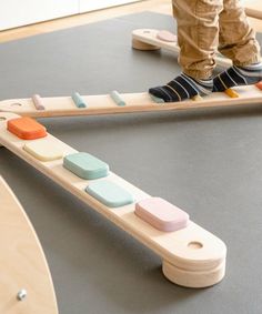 a child standing on top of a wooden toy