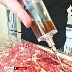 a person is using a meat grinder to cut up some meat on the counter