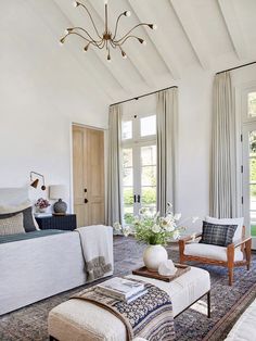 a living room filled with furniture and a chandelier hanging over the top of it