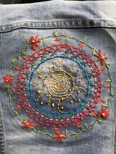 an embroidered design on the back of a jean jacket