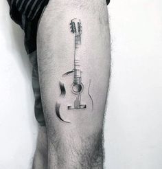 a man's leg with a guitar tattoo on the lower half of his arm