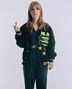 a woman standing in front of a white background wearing green and yellow clothing with stars on it