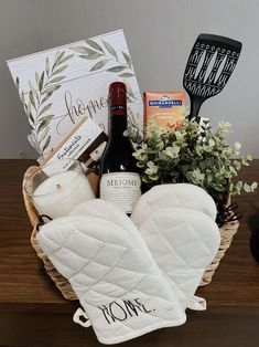 a basket filled with food and wine on top of a wooden table next to a bottle of wine