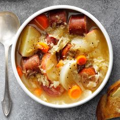 a white bowl filled with soup next to a piece of bread on top of a table