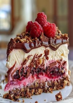 a piece of cheesecake with raspberries and chocolate on top is sitting on a plate