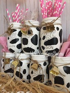 mason jars filled with pink and white paper straws are stacked on top of each other