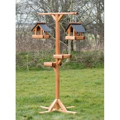 a wooden bird feeder with two birds on it's sides and three small windows