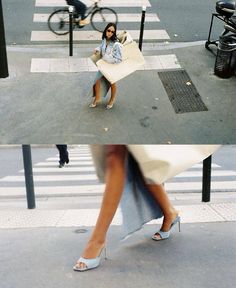 a woman is sitting on a bench in the middle of a crosswalk with her legs crossed