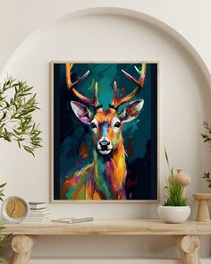 a painting of a deer with antlers on it's head is displayed above a shelf