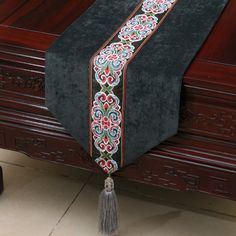 a black table with a tassel on top of it and a wooden box in the background