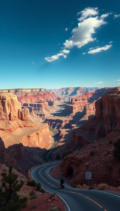 a motorcycle is driving down the road in front of some mountains and canyons at sunset