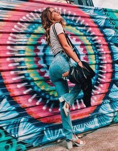 a woman standing in front of a colorful wall