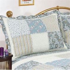 a bed with blue and white quilts on it