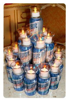 a pile of beer cans with lit candles in them sitting next to a canister