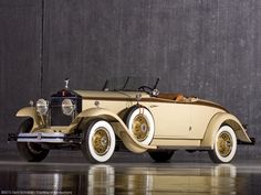 an antique car parked in front of a wall