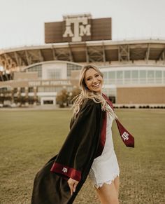 a woman in graduation gown and cap walking across the field at texas state university's football stadium