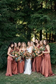 a group of women standing next to each other holding bouquets