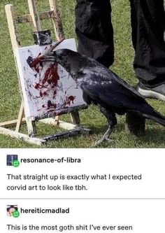 a black bird sitting on top of an easel next to a person's leg