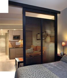 a bedroom with a bed and sliding glass doors in it's center area that leads to the kitchen