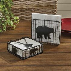 two black and white napkins with bear silhouettes on them sitting on a wooden table