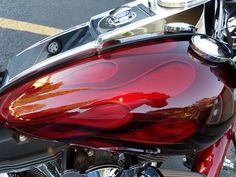 a close up of a red motorcycle parked on the street