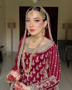 a woman in a red and gold bridal outfit