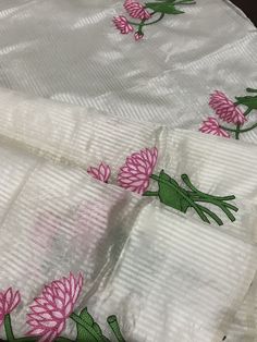 This is a beautiful handloom silk by silk maheswari silk saree in off-white in custom HAND embroidered lotus motif design. Saree is featherlight. It is extremely elegant. Saree pallu is finished with tassels. Falls and pico are done already. Blouse is unstitched and has embroidered lotus motifs. We chose lotus with leaves embroidery to complement the white body of this silk saree. Embroidery was done only in the lower half of the saree,  to maintain the simplicity of the saree, yet adding a pop of colour. Colour may vary slightly depending upon the lighting and individual device settings. Handloom products may have some irregularities unlike power loom products. All sales are final. Dry clean only. White Silk Handloom Dupatta, White Silk Handloom Traditional Wear, White Silk Thread Traditional Wear For Festivals, White Handloom Art Silk Dupatta, White Tissue Silk Dupatta With Floral Embroidery, White Raw Silk Saree, White Floral Embroidered Tissue Silk Dupatta, White Raw Silk Fabric With Embroidered Pallu, White Tussar Silk Fabric With Cutdana Embroidery