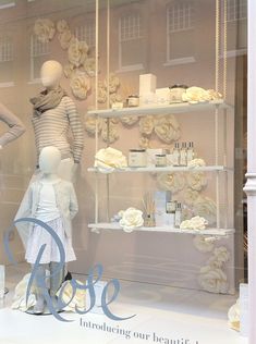 a window display with mannequins and flowers