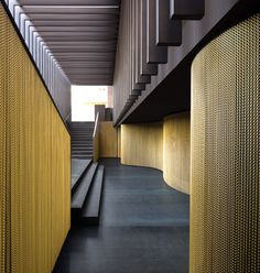 the stairs and railings are lined with gold mesh covering them, along with black concrete flooring