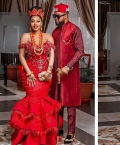 a man and woman dressed in red standing next to each other wearing traditional african garb