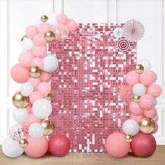 a pink and white balloon arch with balloons