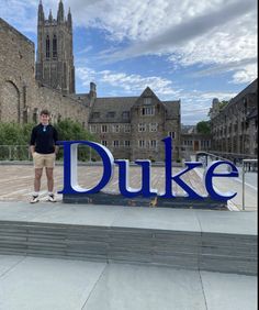 a man standing in front of the duke sign