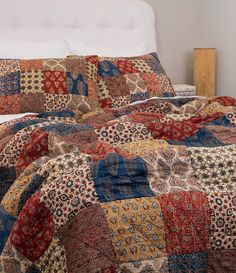 a bed with a colorful quilt on top of it