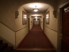 an empty hallway with red carpet and white walls