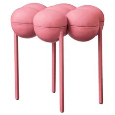 three pink stools sitting next to each other on top of metal legs and feet