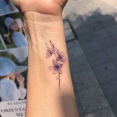 a woman's wrist with a flower tattoo on it