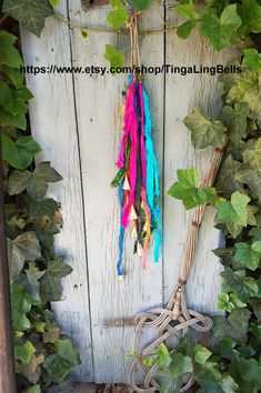 an old pair of scissors hanging on a vine covered wall next to vines and ivy