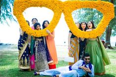 a group of people standing next to each other in front of a yellow flower frame