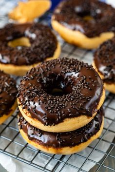 chocolate covered doughnuts sitting on a cooling rack