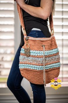 a woman is carrying a crocheted purse