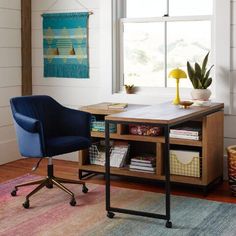 an office with a desk, chair and potted plant in front of the window