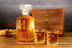 three glasses and a bottle of bourbon on a table next to a wooden box with the label branon