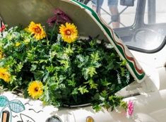 the sunflowers are growing in the flower pot on the car